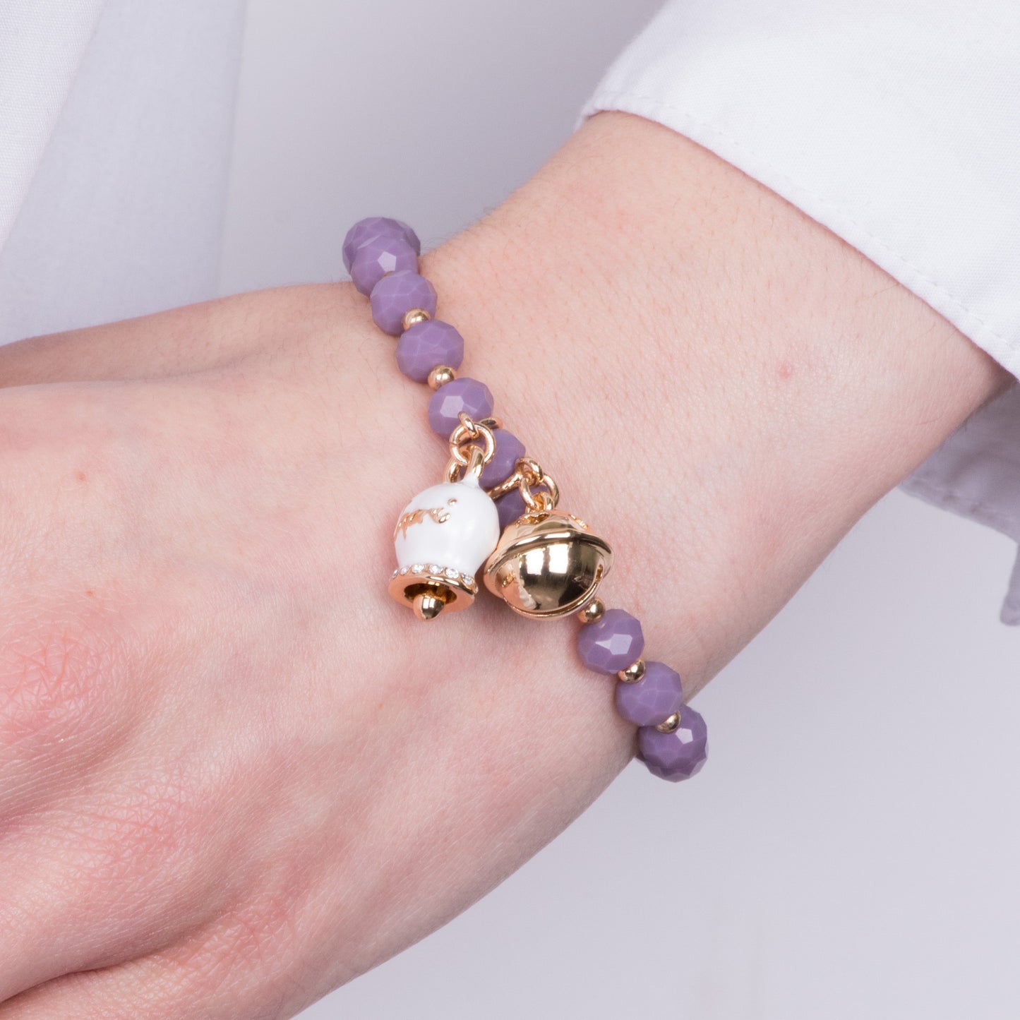 Metal bracelet with white bell and small rattle with black stones